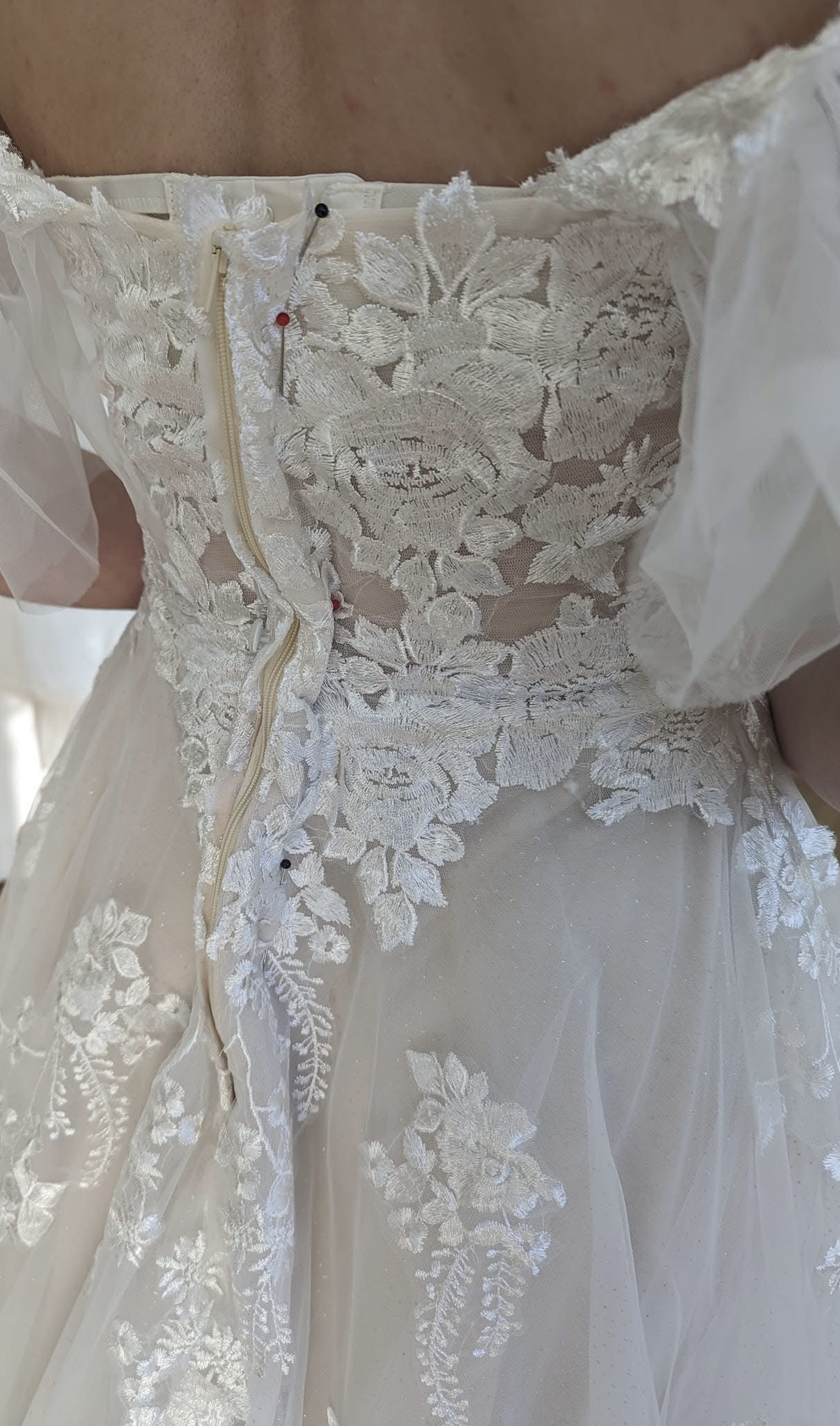 Pinned back detail of a lace dress.