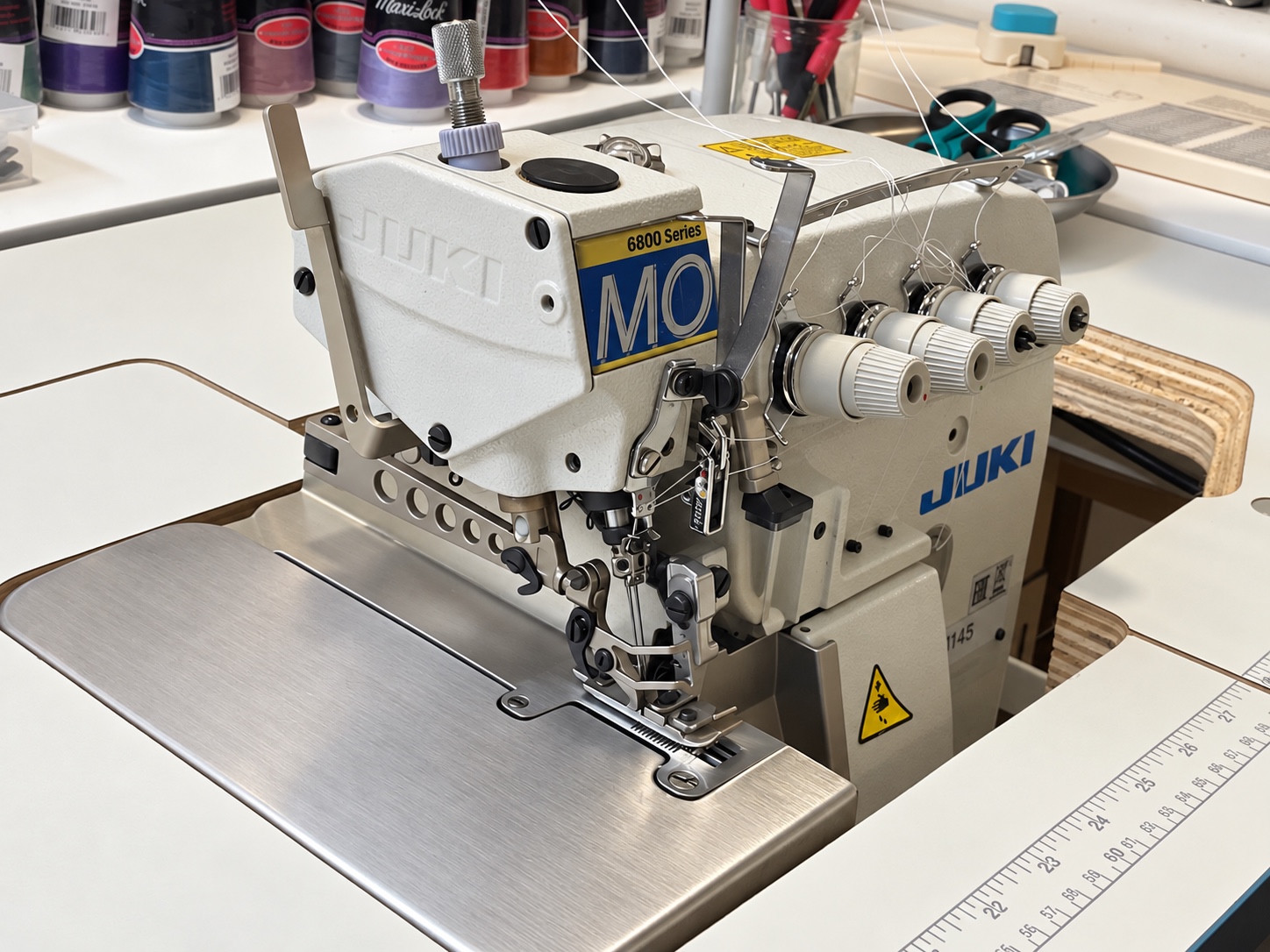 Juki overlock machine with thread cones and sewing tools.